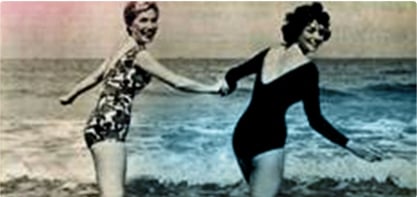 Slika dviju žena u kupaćim kostimima koje se drže za ruke. Slika je staromodna i prikazuje žensku revoluciju.